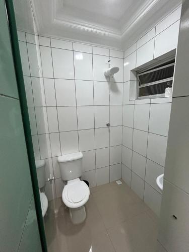 a white bathroom with a toilet and a sink at Cruz De MaIta Hotel in Sao Paulo