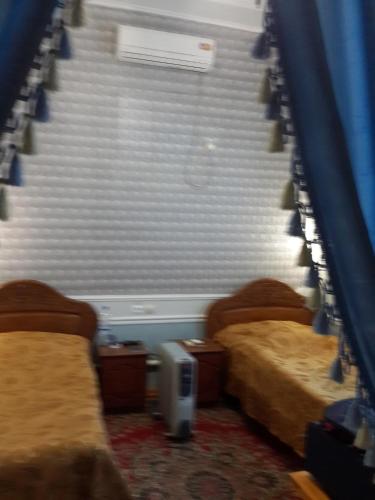 a room with two beds and a staircase at Islambek Hotel & Travel in Khiva