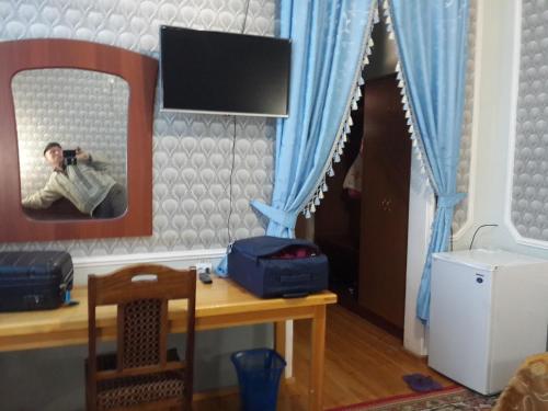 a mirror with a man taking a picture in a room at Islambek Hotel & Travel in Khiva