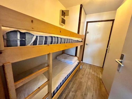 Cette chambre comprend 2 lits superposés et une porte. dans l'établissement Studio Cocooning avec Balcon, Parking Souterrain au Cœur de Samoëns - FR-1-624-70, à Samoëns