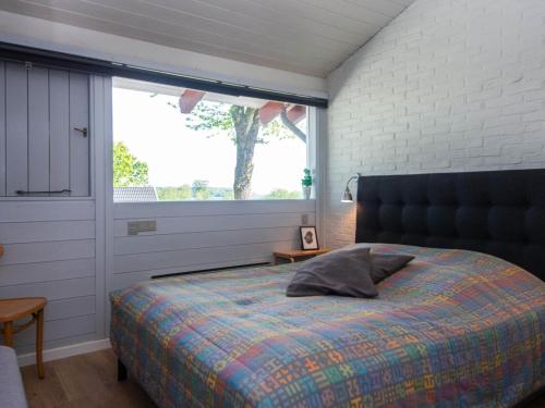 Un dormitorio con una cama y una ventana grande. en 4 star holiday home in Aabenraa, en Aabenraa