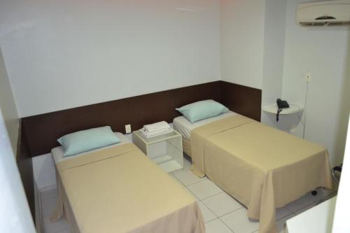 Habitación hospitalaria con 2 camas y lavamanos en Hotel Ideal en Teresina