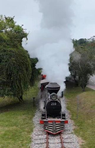 a steam train is coming down the tracks at Casa no centro de Miguel Pereira in Miguel Pereira