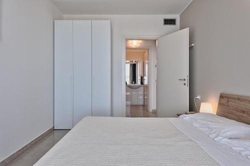 a bedroom with white walls and a large bed at Magnolie Suite Bella vista a 2 passi dal mare in Eraclea Mare