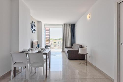 a living room with a table and chairs and a couch at Magnolie Suite Bella vista a 2 passi dal mare in Eraclea Mare