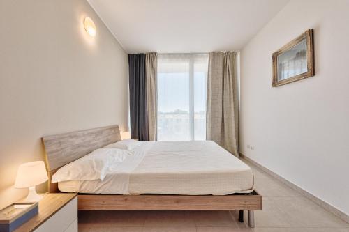 a bedroom with a bed and a window at Magnolie Suite Bella vista a 2 passi dal mare in Eraclea Mare