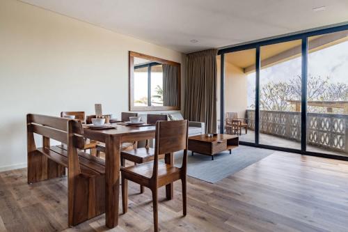 a dining room with a table and chairs and a balcony at Spacious Apartment with Balcony in El Zonte