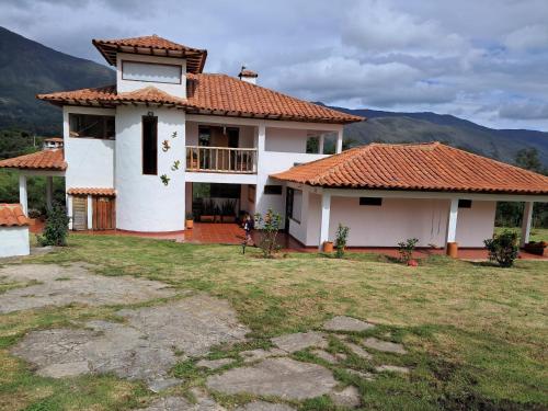 a white house with a red tile roof at Casa Villa Victoria in Villa de Leyva