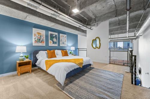a bedroom with a large bed and a blue wall at King and Queen 2-Story Loft with 2 Ensuite Baths and Private Balcony at Atlantic Station in Atlanta