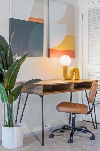 a wooden desk with a chair and a plant at Spacious 2 Bed 2 Ensuite Bath Loft in Atlantic Station in Atlanta