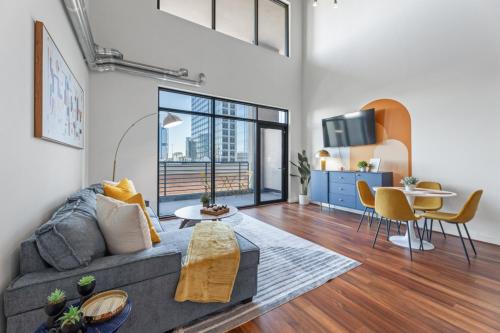 a living room with a couch and a table at King and Queen 2-Story Loft with 2 Ensuite Baths and Private Balcony at Atlantic Station in Atlanta