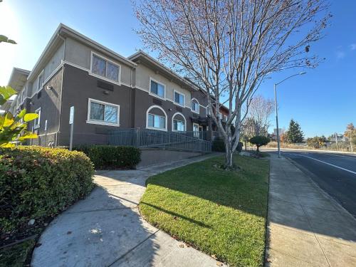 a house on the side of a street with a tree at Holiday Inn Express & Suites Mountain View Silicon Valley by IHG in Mountain View