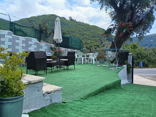 a patio with a table and chairs and an umbrella at Aggelikas apartments in Paleokastritsa