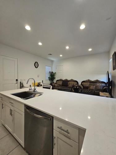 a kitchen with a sink and a living room at genie palace at statefarm stadium in Phoenix