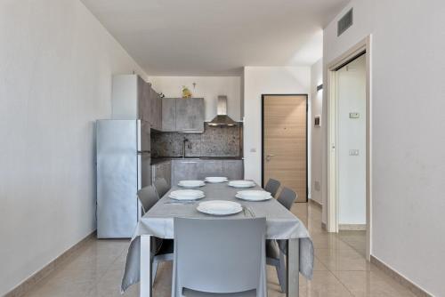 a dining room with a table and a refrigerator at Magnolie A37, Vista & comfort vicino al mare in Eraclea Mare
