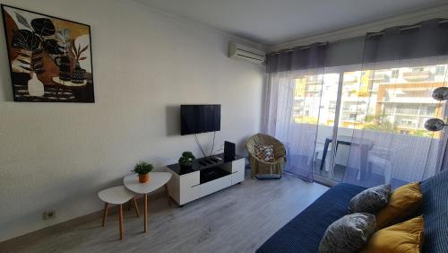 a living room with a couch and a tv at Apartamento T1 centro Albufeira in Albufeira