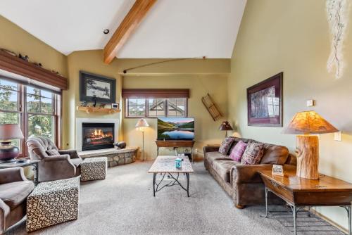 Una sala de estar con sofás y chimenea. en Breckenridge Condo with Sauna & Hot Tub Access, en Breckenridge