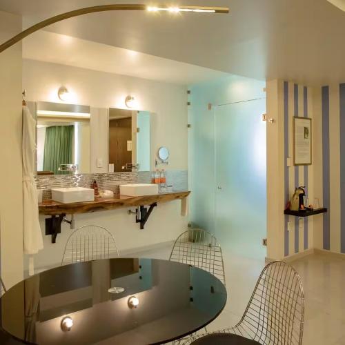 a bathroom with a glass table and two chairs at TRES79 Hotel Boutique Orizaba in Orizaba