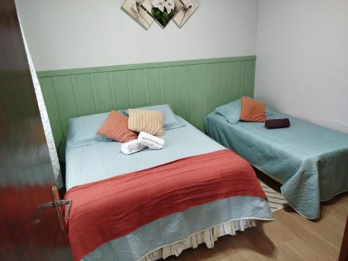 two beds sitting next to each other in a room at Chalé Elohim Campos do Jordão in Campos do Jordão