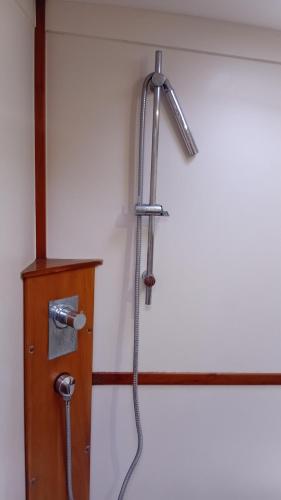 a shower with a hose attached to a wall at LUNA BAY, voilier 3 cabines 2 sdb en ville in Sète
