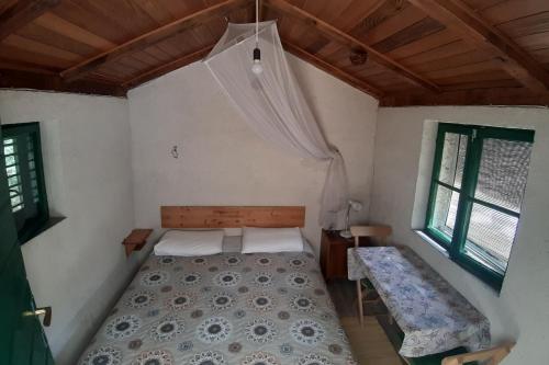 a bedroom with a bed and a table and window at Secluded holiday house Pasman - 15649 in Pašman