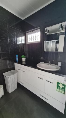 a bathroom with a white sink and a mirror at Apartamento T1 centro Albufeira in Albufeira