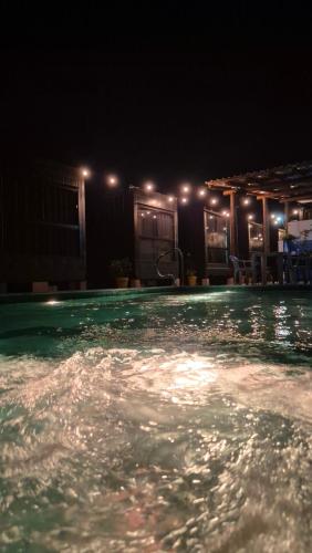 an outdoor swimming pool at night with lights at Aldeia Mar in Bertioga