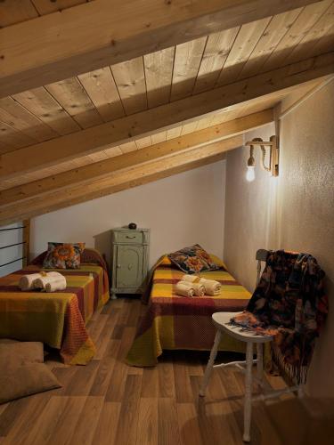 a bedroom with two beds and a table and a chair at Rosa Life House in Gasponi