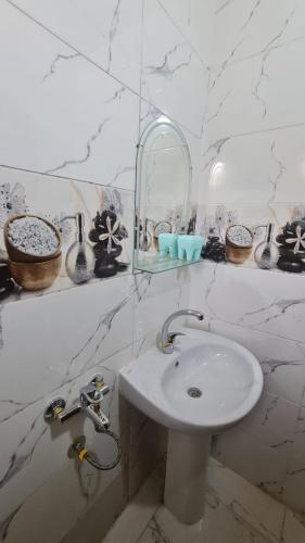 a white bathroom with a sink and a mirror at Toto Kato in Jazīrat Aswān