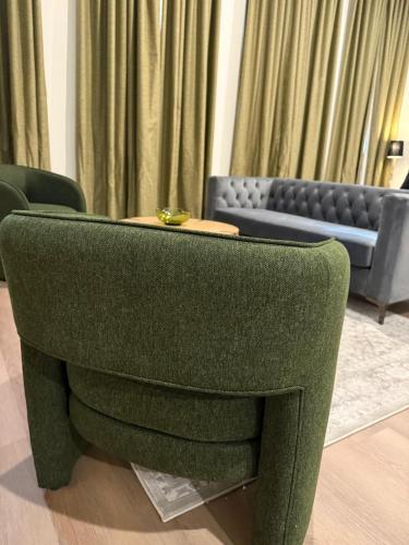a green chair in a living room with a couch at Unicorn Zebra in Tucson