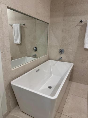 a white bath tub in a bathroom with a mirror at Unicorn Zebra in Tucson