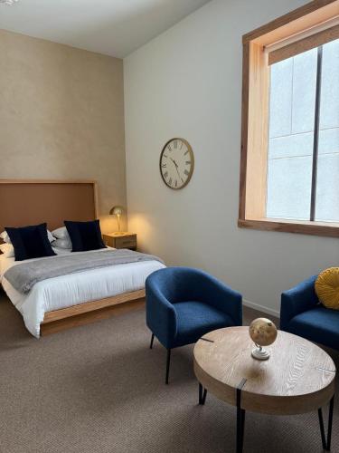 a bedroom with a bed and a clock on the wall at Unicorn Zebra in Tucson