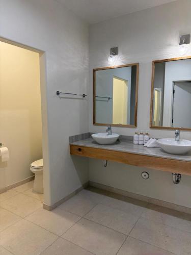a bathroom with two sinks and two mirrors at Unicorn Zebra in Tucson