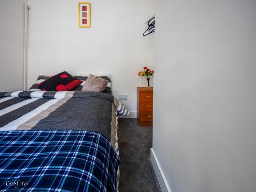 a bedroom with a bed and a dresser at Newlands Lodge Double Room 1 in Stoke on Trent