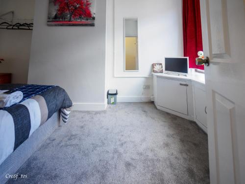 a bedroom with a bed and a window and a television at Newlands Lodge Double Room 1 in Stoke on Trent