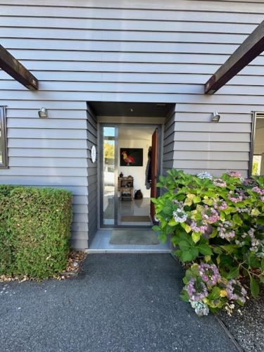 a house with a door leading into a room with flowers at Chartres Retreat in Arrowtown