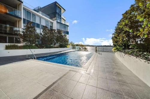 a swimming pool in front of a building at Spacious Lakefront Apartment with Pool Access in Kingston