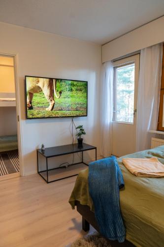 a bedroom with a tv hanging on the wall at Cosy one bedroom apartment with balcony in Rovaniemi