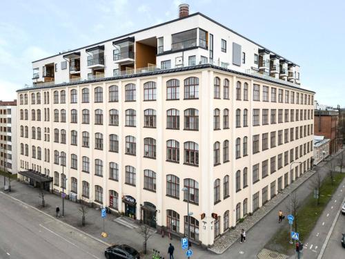 a large white building with people walking in front of it at Come in! "Värjäri" Stunning studio in newly built building in Pyynikki area! in Tampere