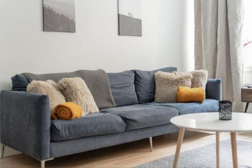 a blue couch with pillows on it in a living room at Come in! "Värjäri" Stunning studio in newly built building in Pyynikki area! in Tampere