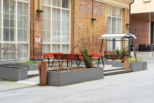 a group of benches sitting in front of a building at Come in! "Värjäri" Stunning studio in newly built building in Pyynikki area! in Tampere
