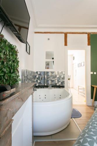 La salle de bains est pourvue d'une grande baignoire au milieu. dans l'établissement La bulle de Canclaux, balnéo, à Nantes