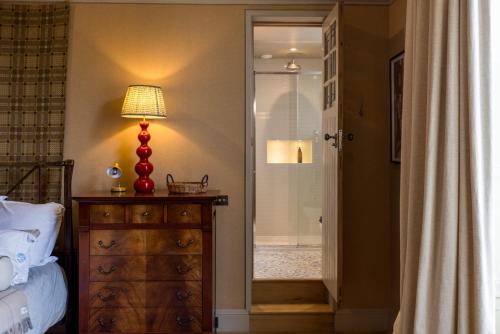 Un dormitorio con una cama y una lámpara en un tocador en Luxury Wood panelled West End GF Flat, en Edimburgo