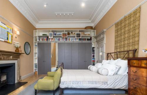 Un dormitorio con una cama y una chimenea. en Luxury Wood panelled West End GF Flat, en Edimburgo
