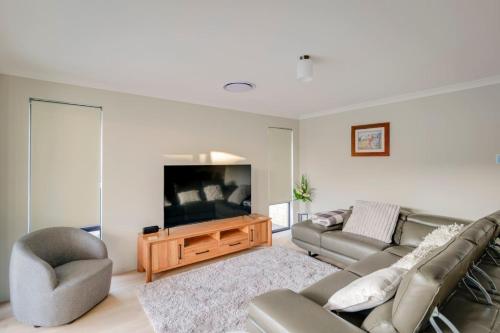 a living room with a couch and a flat screen tv at Stables Lane Retreat in Busselton