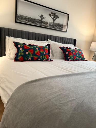 a white bed with two pillows on top of it at Unicorn Zebra in Tucson