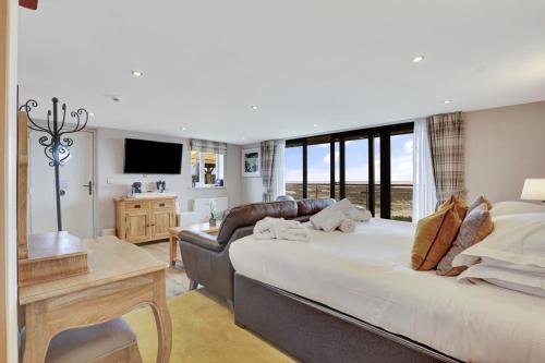 a bedroom with a large bed and a living room at Beach House - North East Escapes in Boulmer