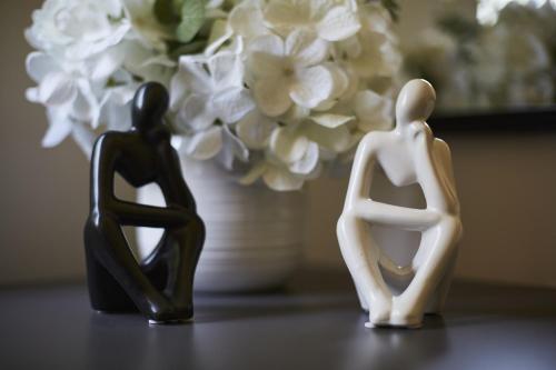 two plastic figurines sitting next to a vase with flowers at Hayy Luxury Retreat At The Lodge in Bradford