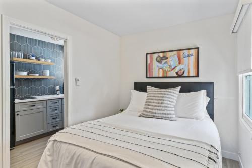 a white bedroom with a bed and a kitchen at Balboa Island Cottage Air Conditioning Newport Peninsula Ferry Close in Newport Beach