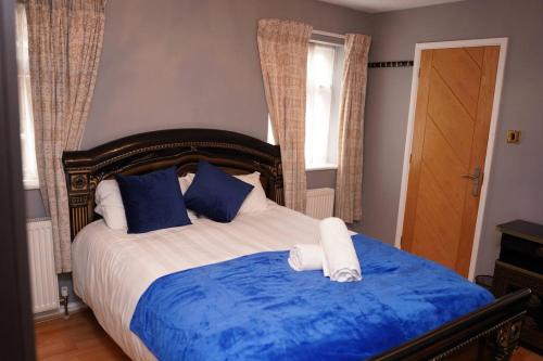 a bed with blue and white sheets and blue pillows at Blossom House* For Large Groups* Near Sutton Park* in Birmingham